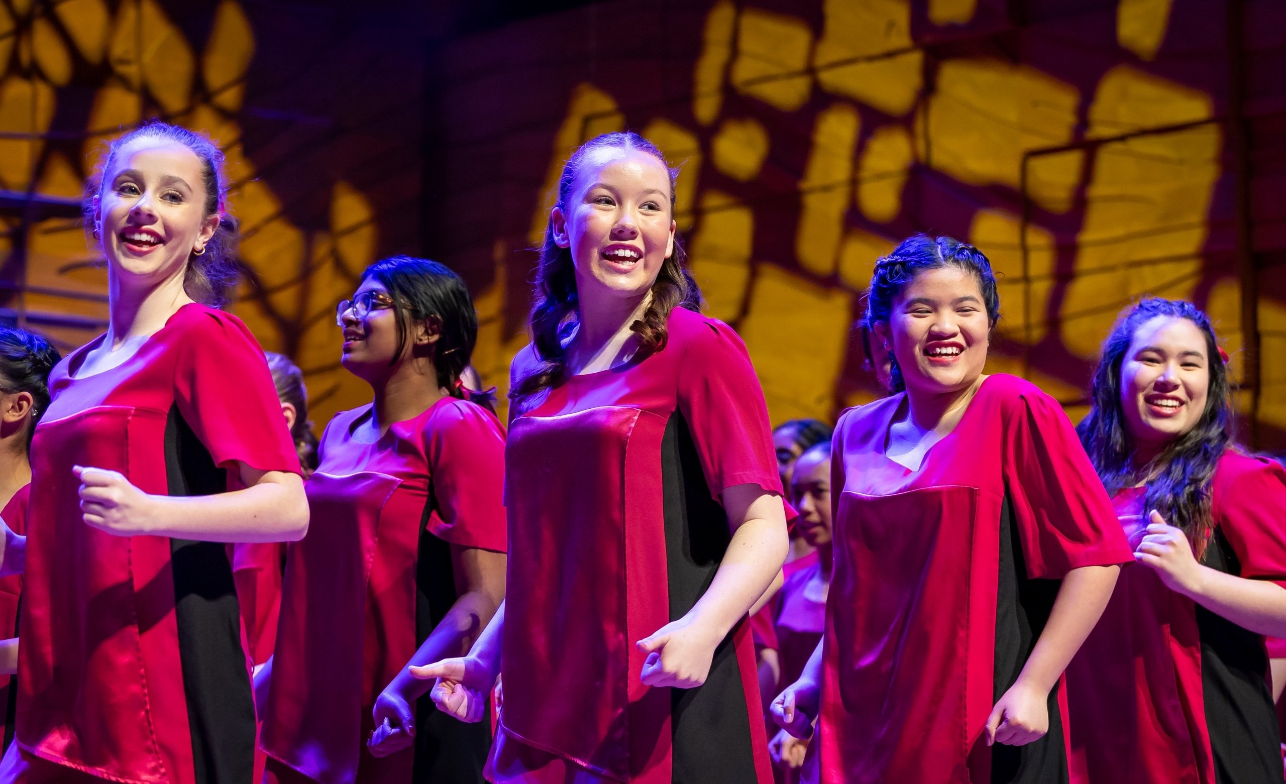 girsl in red silk perfromance tops dancing on stage