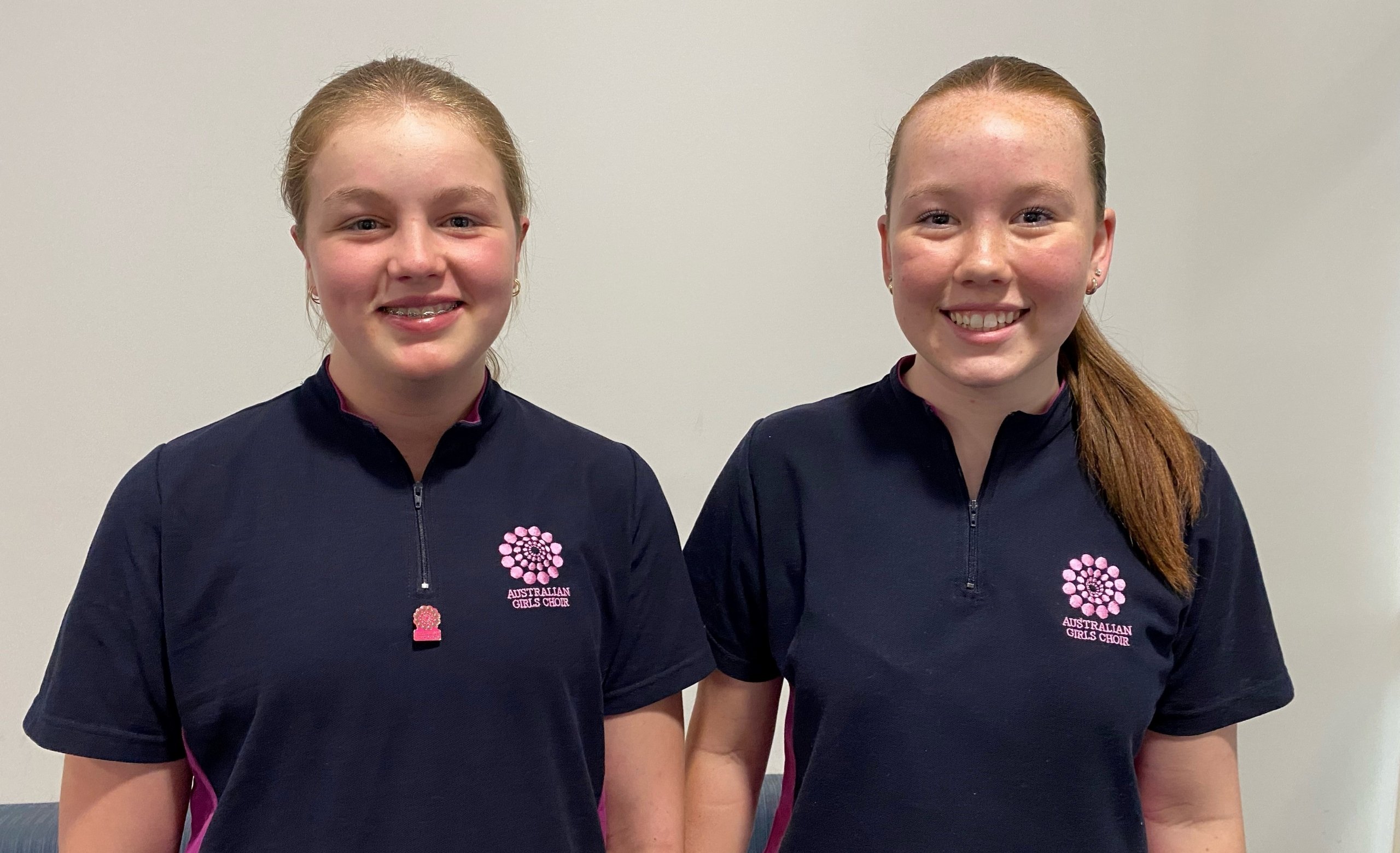 two girls smiling in navy shirts