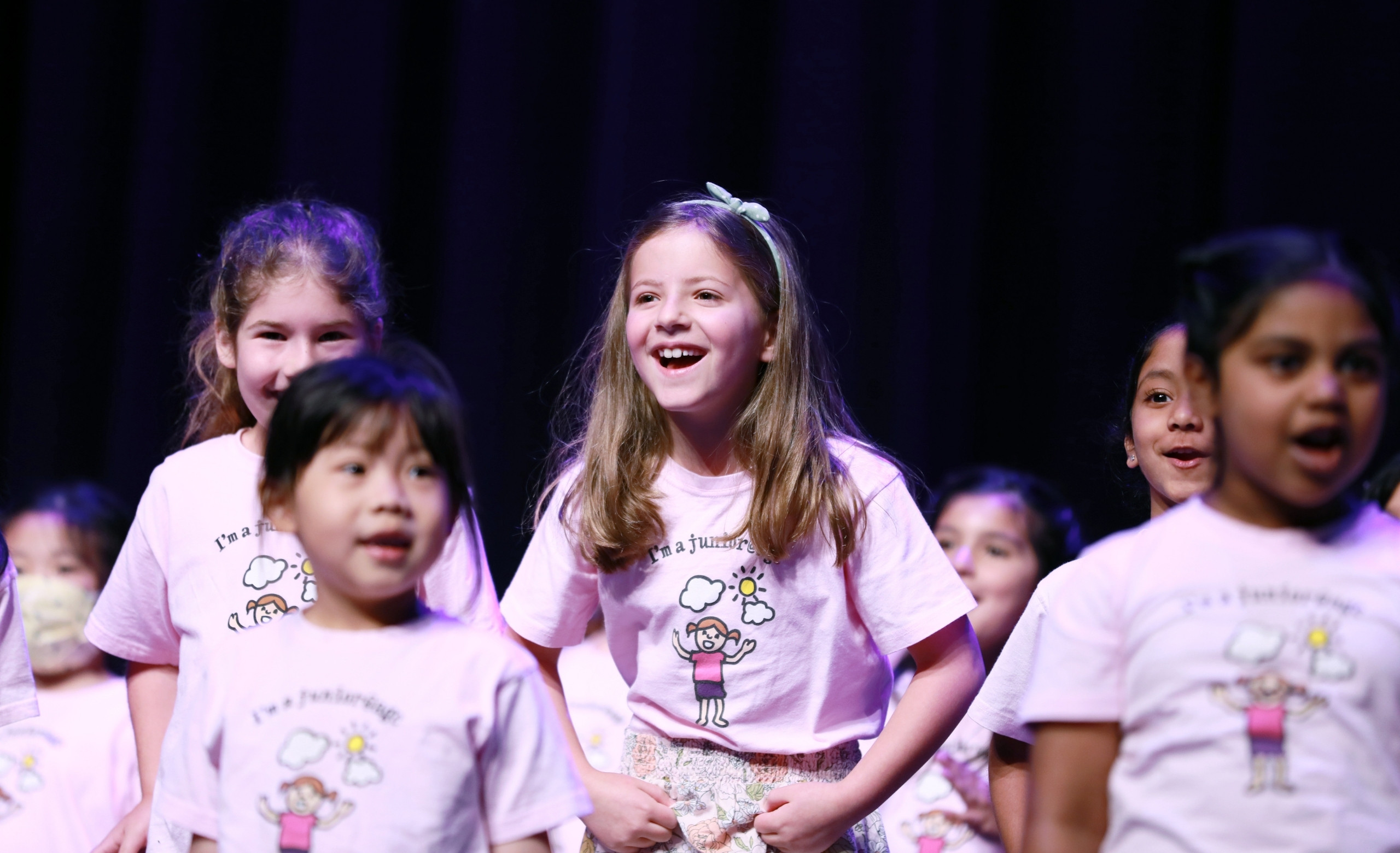 girls in light pink shirts on stage