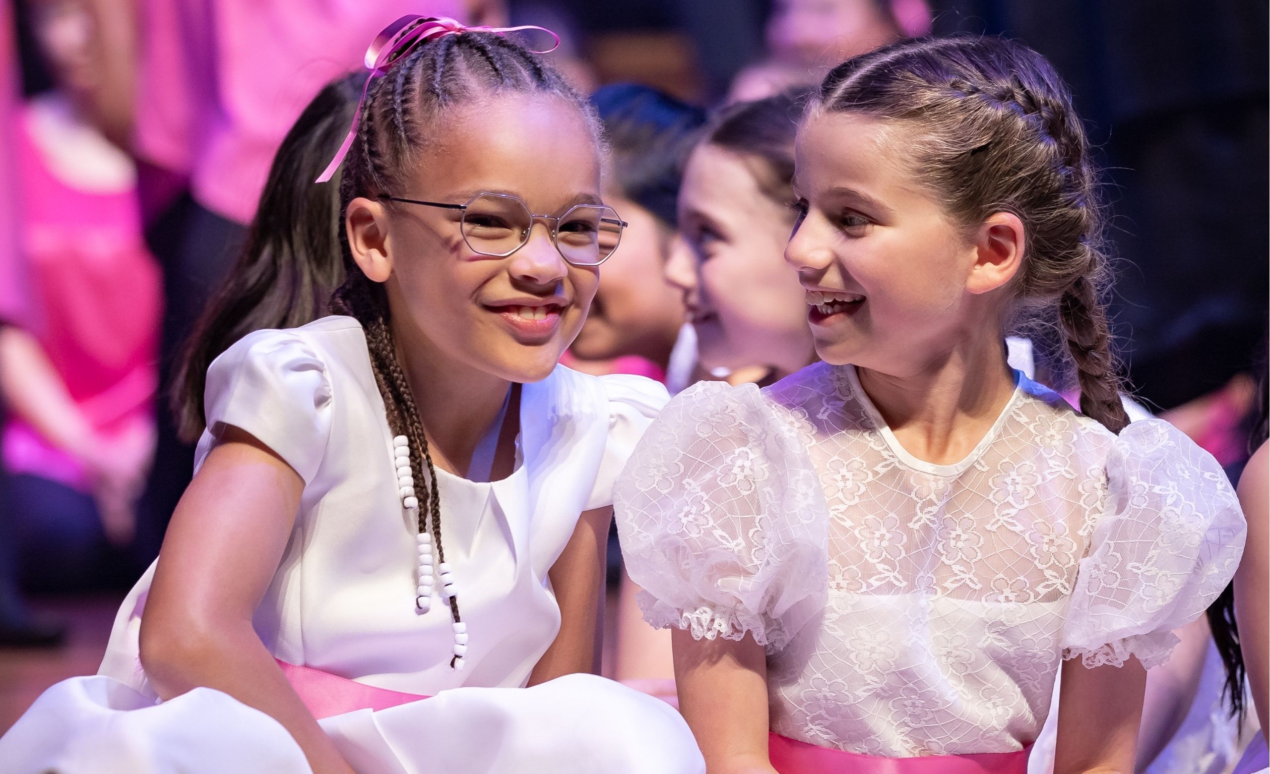 Two girls laugh on stage together