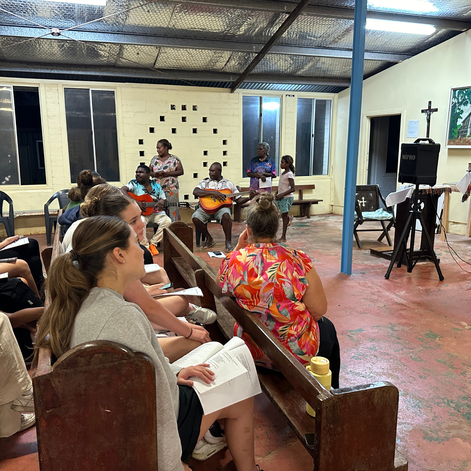 Group of choristers and Lockhart River locals wait for church service and hymns to begin