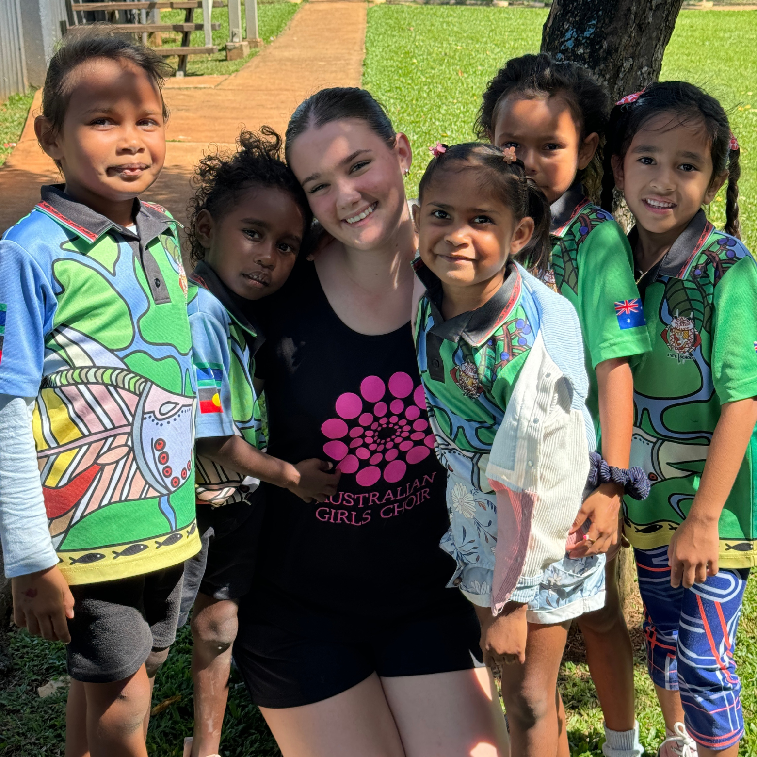 One AGC chorister poses with a group of Lockhart resident children