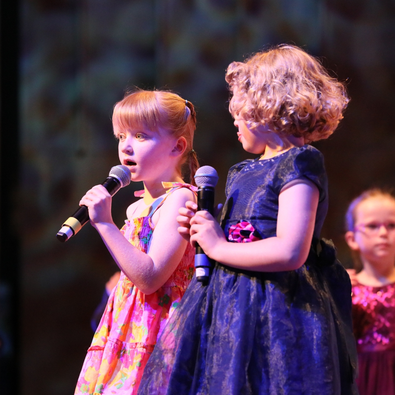 two young girls performing on stage