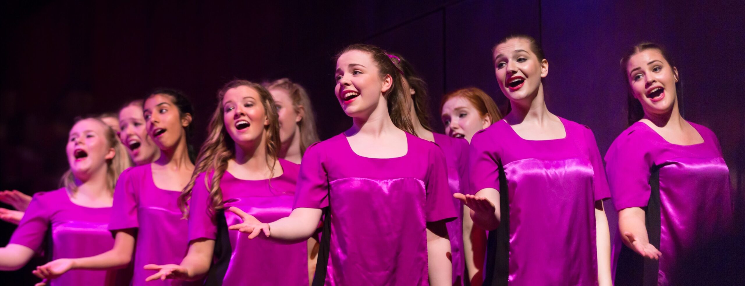 AGC in silk magenta uniform on stage singing