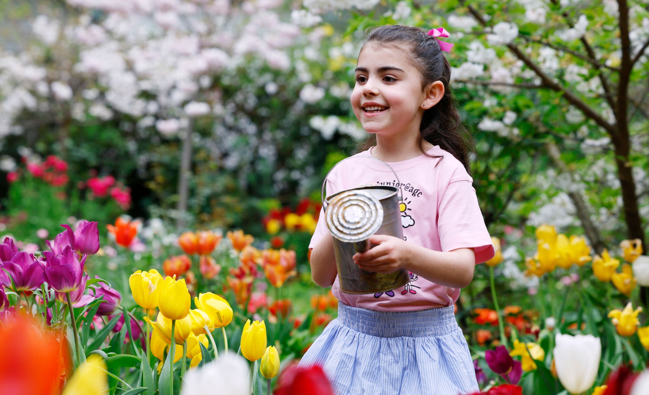 junior@agc chorister waters the flowers in the beautiful colourful garden