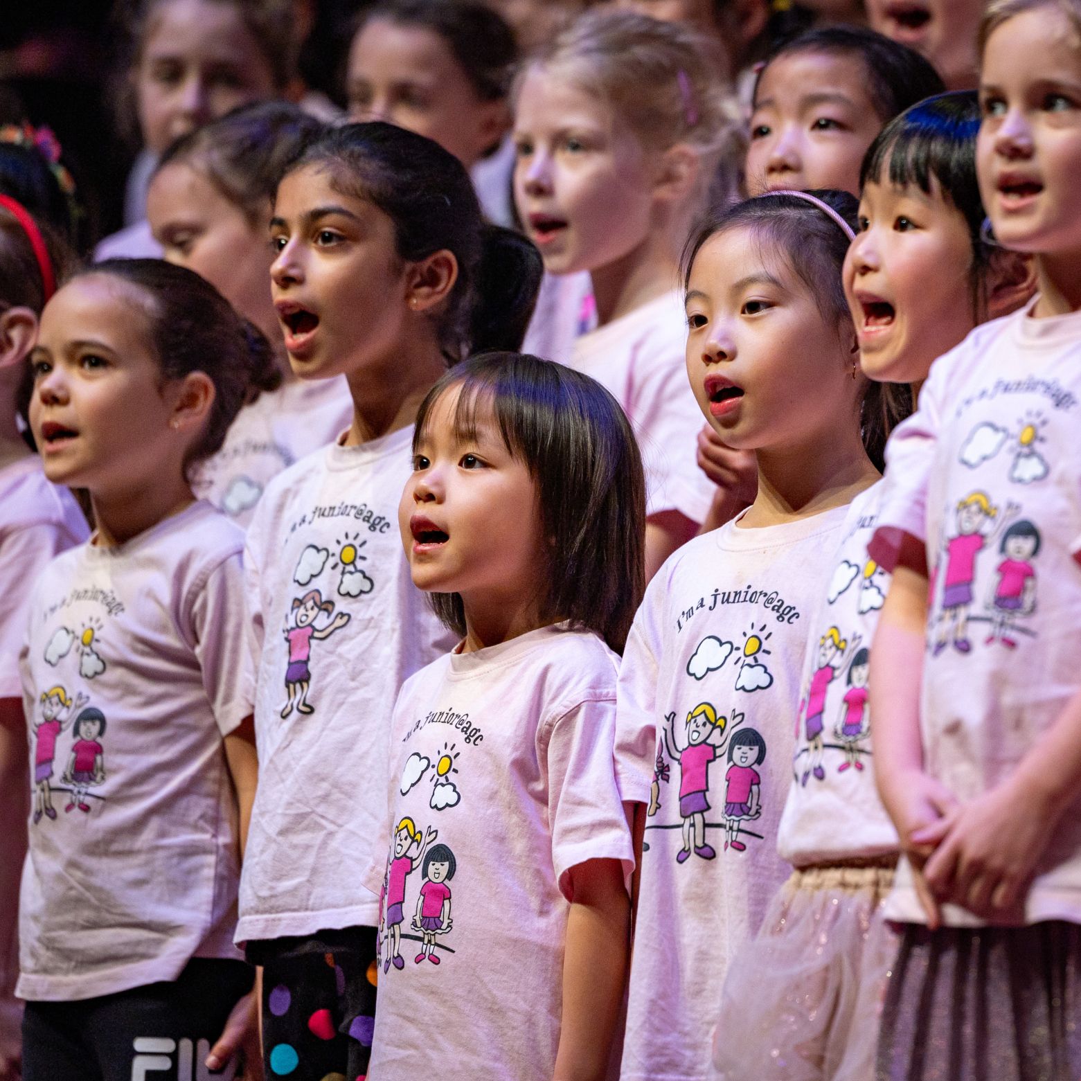 junior@agc choristers sing on stage together