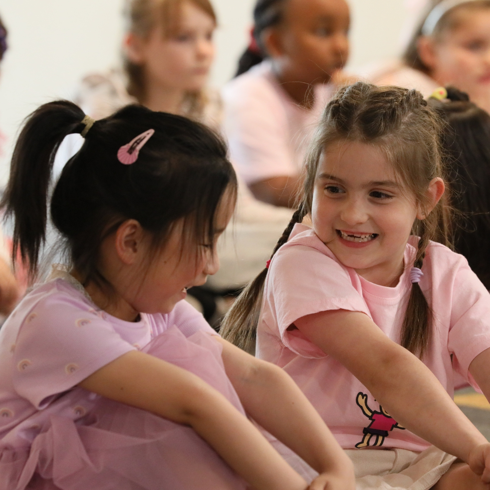 girls in pink sitting in class