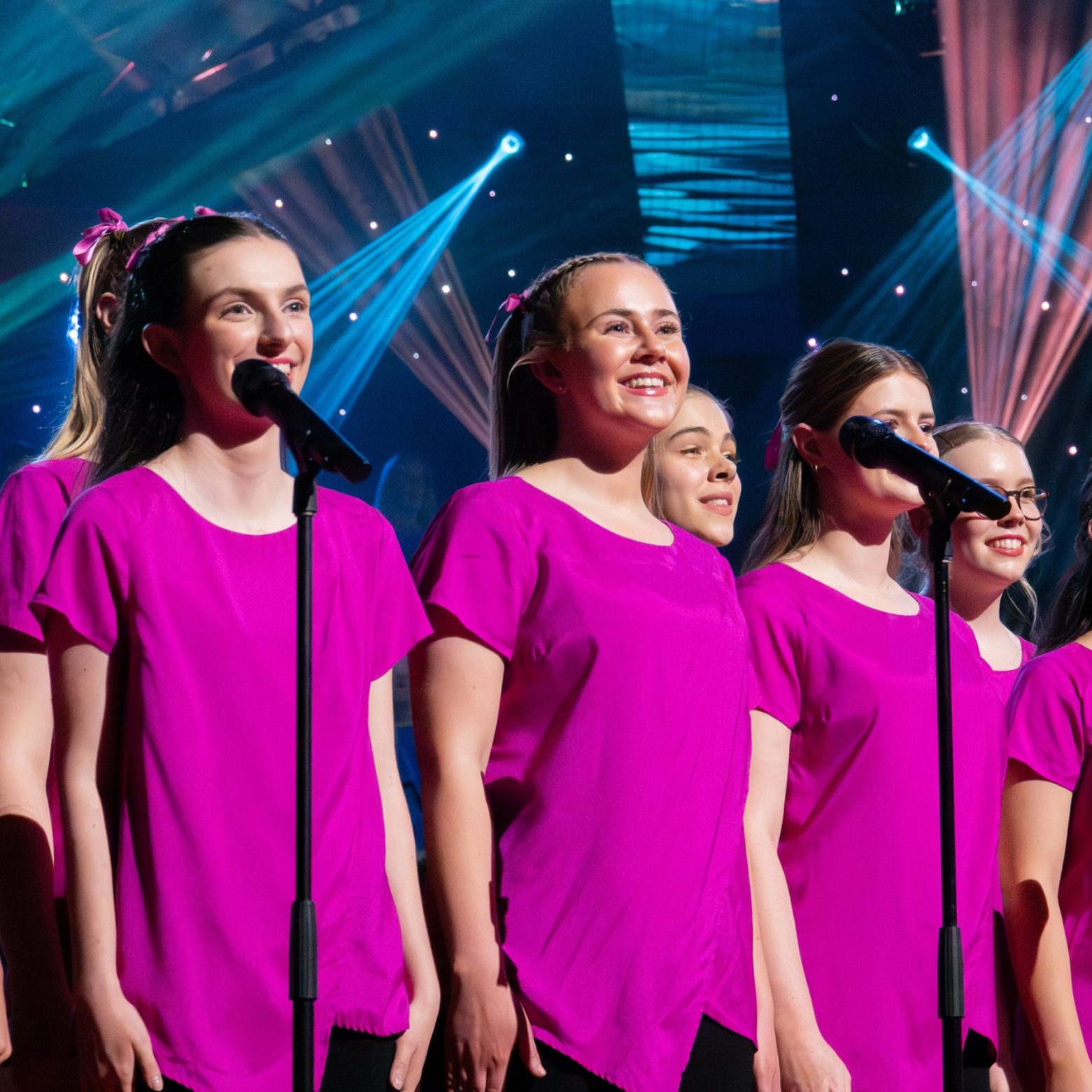 AGC Carols performance on stage in pink top